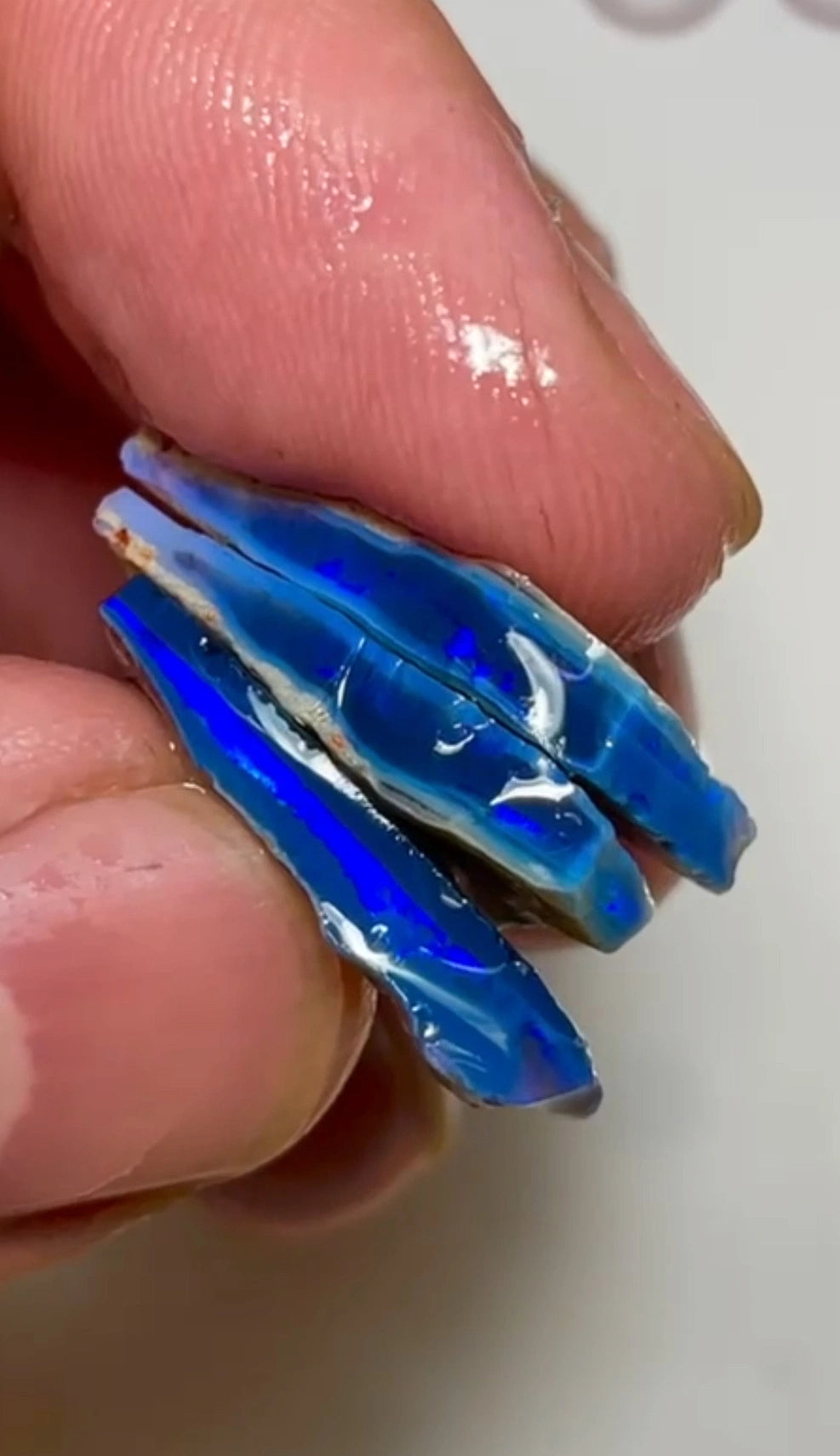 Stapel blauer Rohopale auf schwarzem Grund